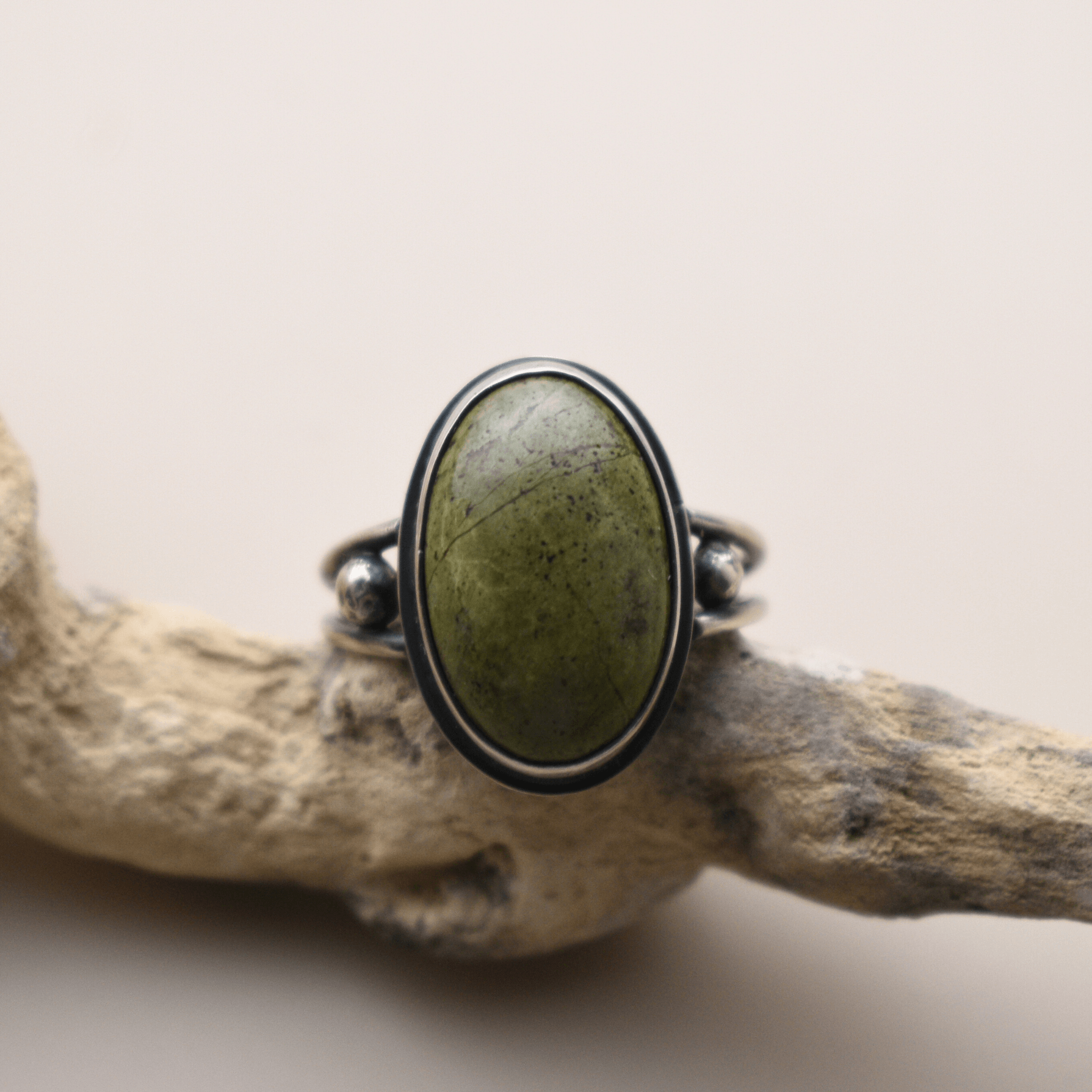 A silver ring with a green oval stone