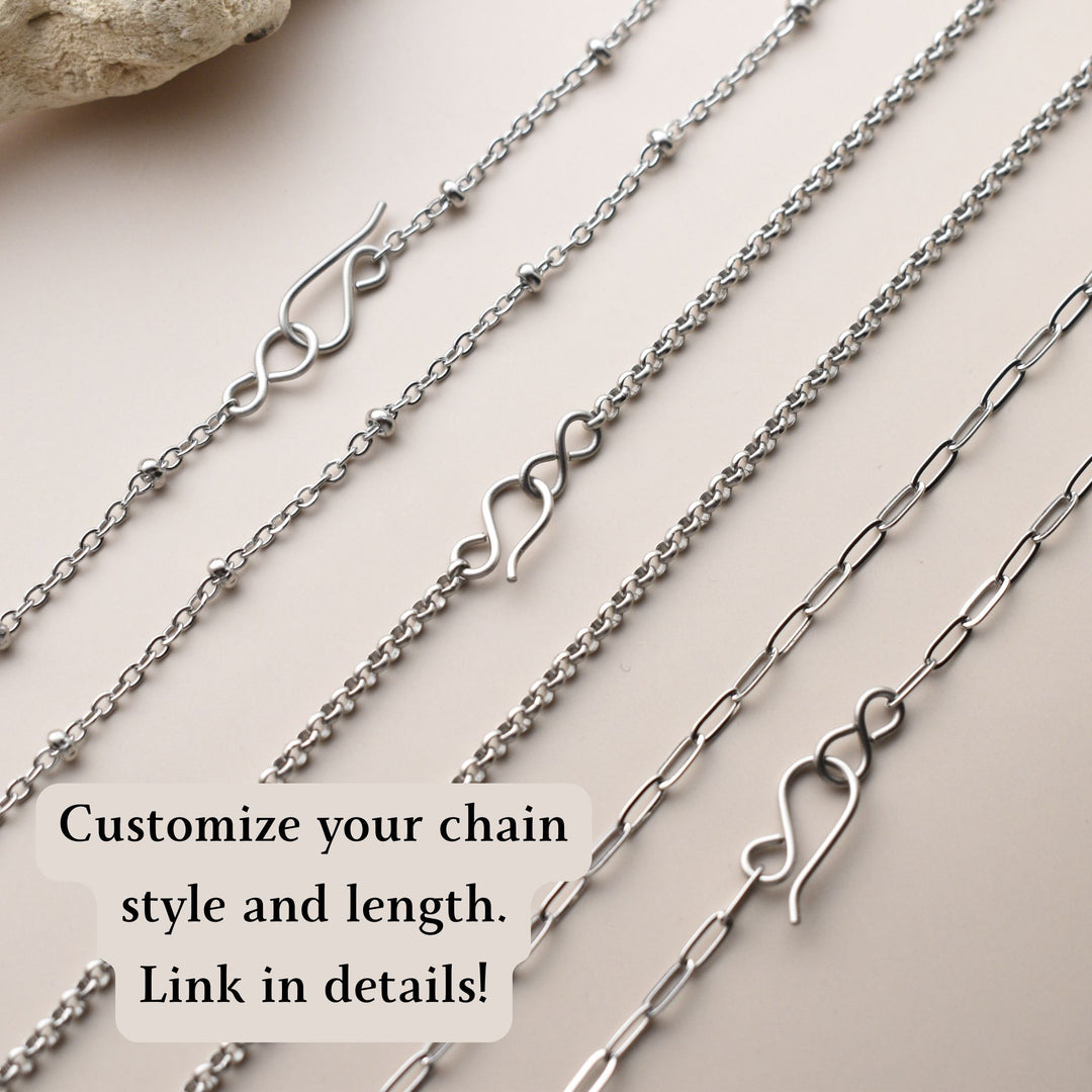 Collection of silver chains with various designs on a light background