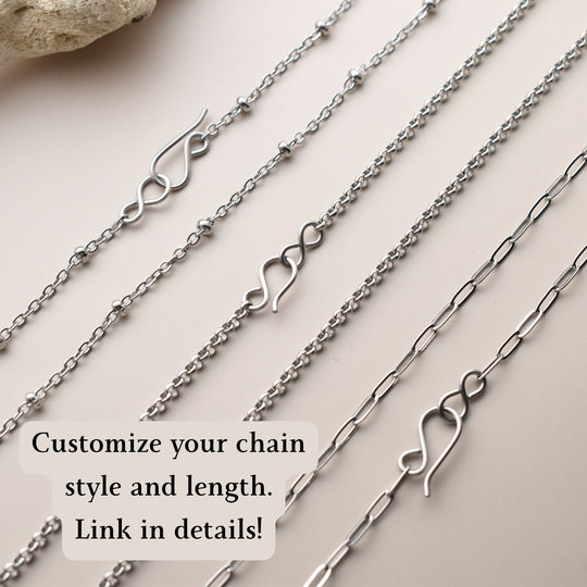 Collection of silver chains with various designs on a light background
