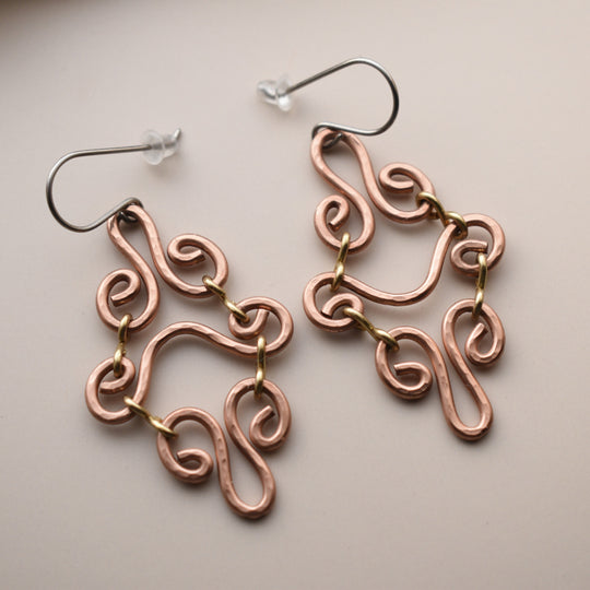 Copper wire earrings on a beige background