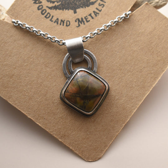 Jasper necklace with a pendant on a brown card, featuring Woodland Metalsmith branding.