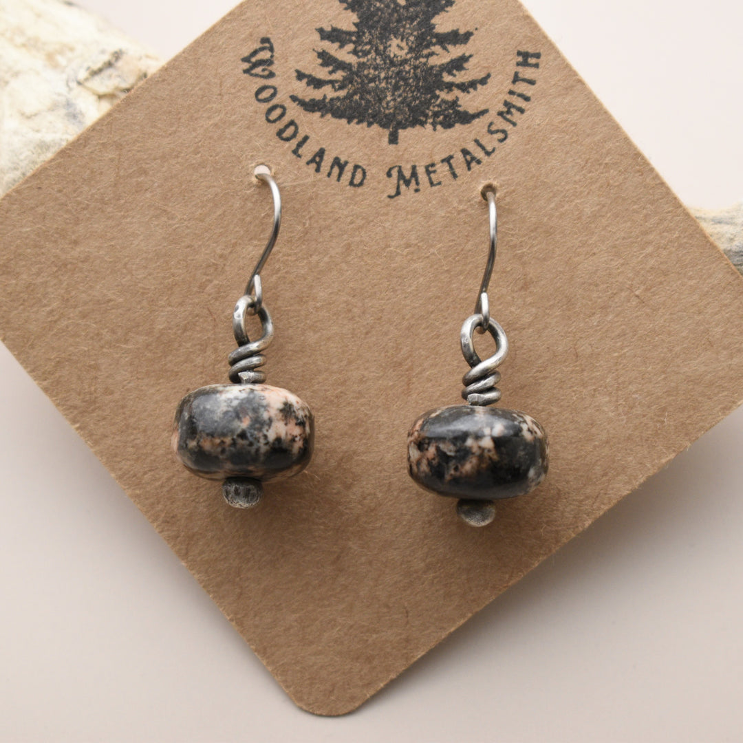 Pair of Orthoclase silver earrings on a 'Woodland Metalsmith' branded card.