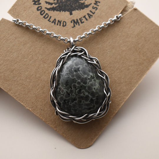 Necklace with a Variolite stone pendant on a brown card with 'Woodland Metalsmith' branding.