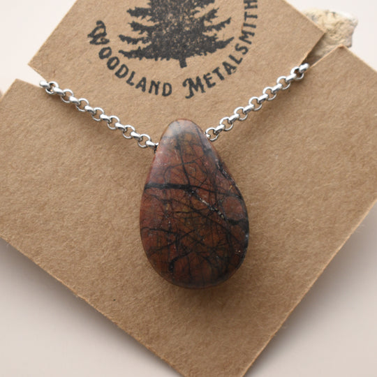 Necklace with a teardrop-shaped orange Jasper pendant on a 'Woodland Metalsmith' card.
