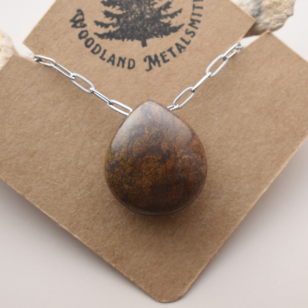Necklace with a brown pendant on a Woodland Metalsmith card